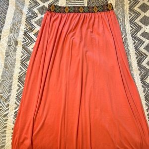 Long coral colored skirt with multi-colored waist band